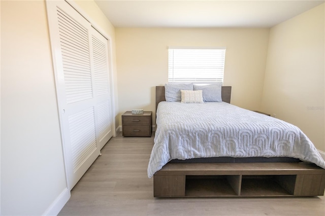 bedroom featuring light wood-style floors, a closet, and baseboards