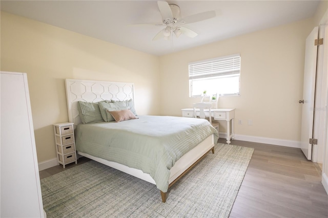 bedroom with ceiling fan, baseboards, and wood finished floors