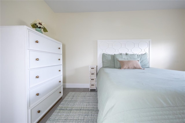 bedroom with dark wood-type flooring and baseboards