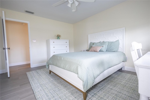 bedroom featuring a ceiling fan, baseboards, visible vents, and wood finished floors