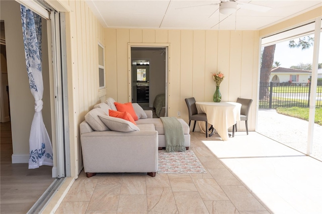 living area with a sunroom and a ceiling fan