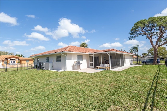 back of house with a sunroom, a fenced backyard, a tile roof, and a yard