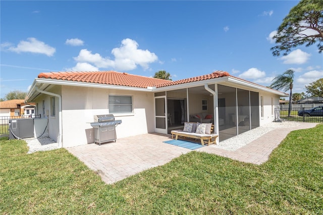 rear view of house featuring a yard, a patio, fence, and a tiled roof