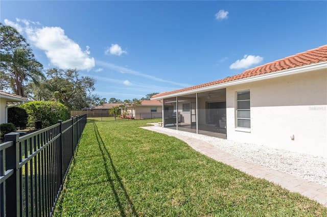 view of yard featuring a sunroom, a fenced backyard, and a patio