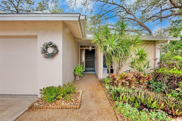 property entrance featuring an attached garage and stucco siding