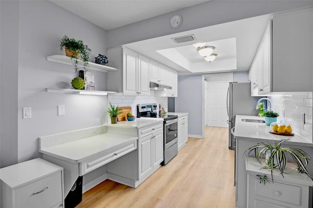 kitchen with a tray ceiling, stainless steel electric range oven, open shelves, visible vents, and under cabinet range hood