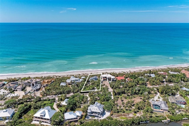 birds eye view of property featuring a water view and a beach view