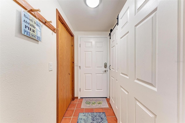 entryway with light tile patterned floors and a barn door