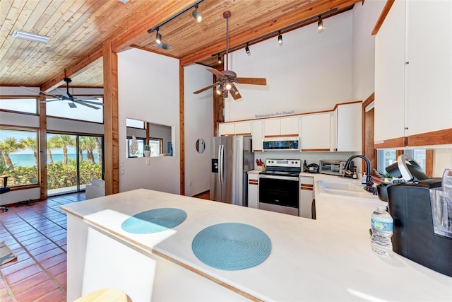 kitchen featuring stainless steel appliances, wood ceiling, and high vaulted ceiling