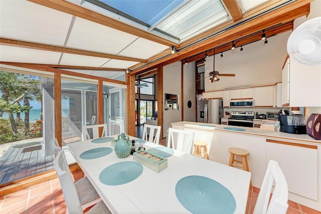 dining room with ceiling fan and a high ceiling