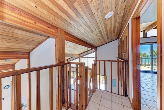 hallway featuring lofted ceiling, wood ceiling, and light tile patterned floors