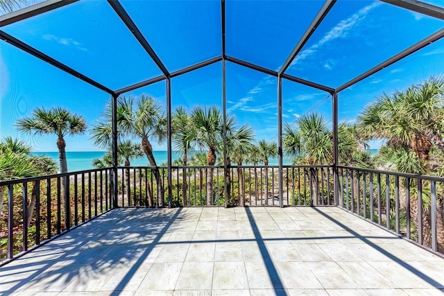 view of patio / terrace featuring a lanai and a water view