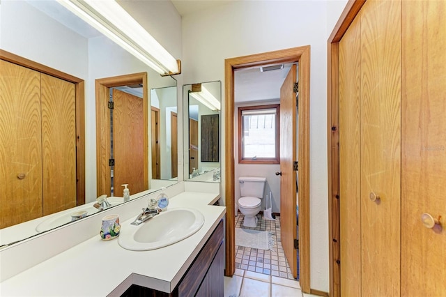 bathroom featuring a closet, vanity, toilet, and tile patterned floors