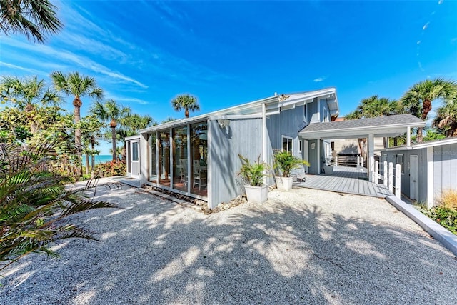 back of house featuring a wooden deck and a sunroom