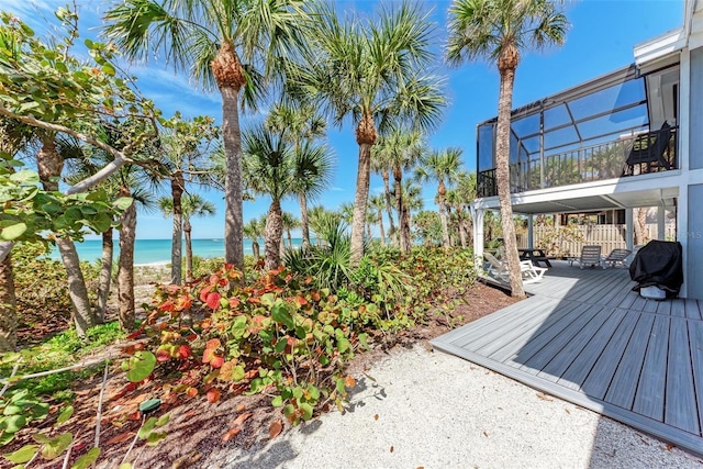 view of yard with a beach view and a deck with water view