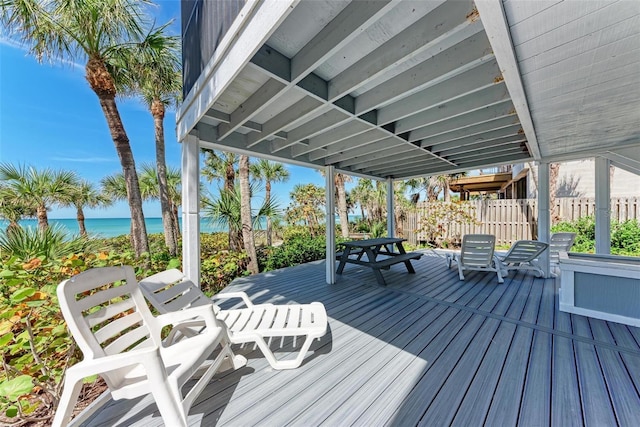 wooden terrace with a water view and fence