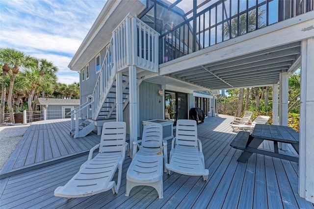 wooden terrace featuring stairs and outdoor dining area