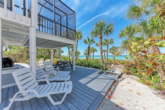 deck featuring a water view and a beach view