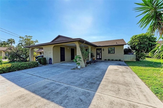 view of front of property featuring fence, a front lawn, and stucco siding