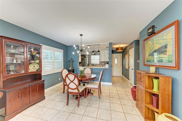 dining room featuring a chandelier, baseboards, and light tile patterned floors