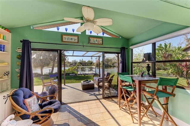 sunroom featuring a ceiling fan, lofted ceiling, and a water view