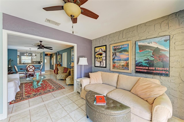 living room featuring tile patterned flooring, visible vents, and ceiling fan