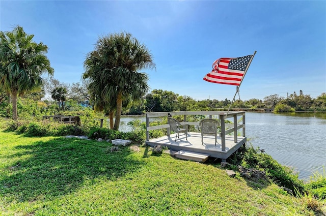 view of dock with a lawn and a deck with water view