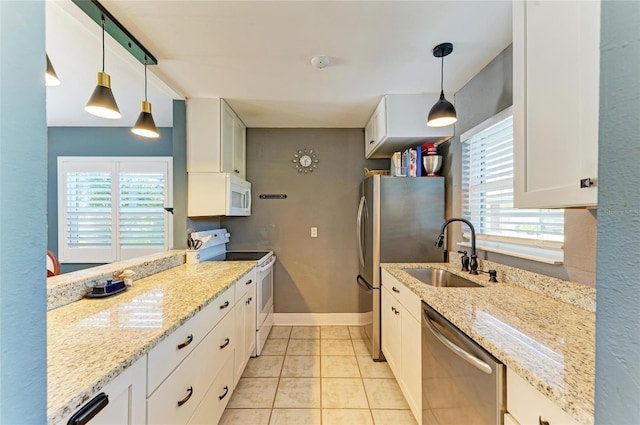 kitchen featuring a sink, white cabinetry, baseboards, appliances with stainless steel finishes, and light stone countertops