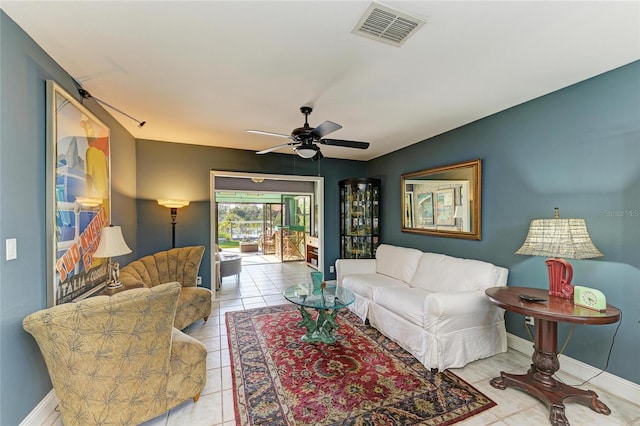 living room with tile patterned flooring, visible vents, ceiling fan, and baseboards