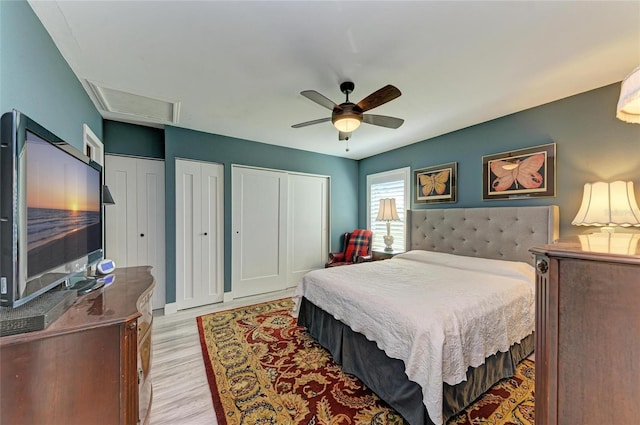 bedroom featuring multiple closets, a ceiling fan, and light wood-style floors