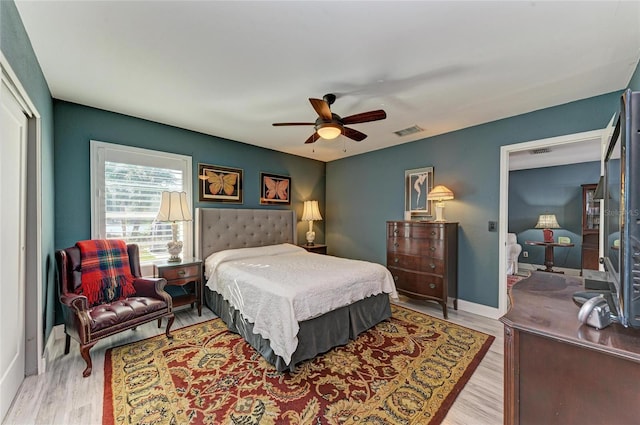 bedroom featuring baseboards, visible vents, a ceiling fan, wood finished floors, and a closet