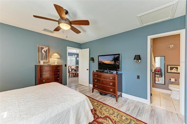 bedroom with ensuite bath, light wood-style floors, attic access, and visible vents