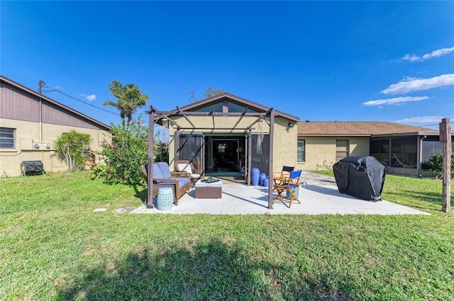 rear view of property with a patio, a lawn, a sunroom, and stucco siding