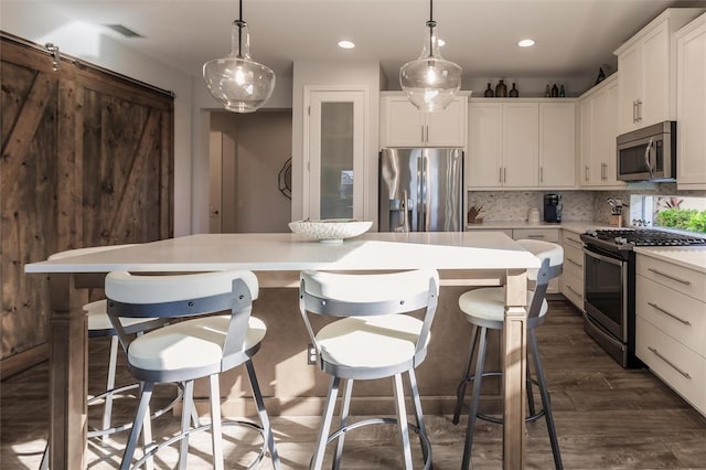 kitchen featuring stainless steel appliances, visible vents, backsplash, a center island, and dark wood-style floors