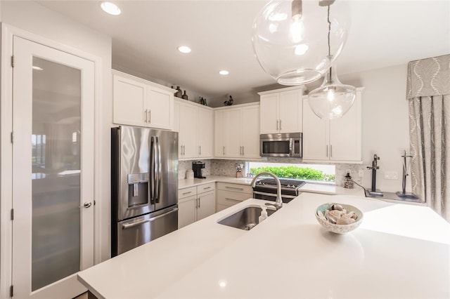 kitchen with backsplash, stainless steel appliances, a sink, and light countertops