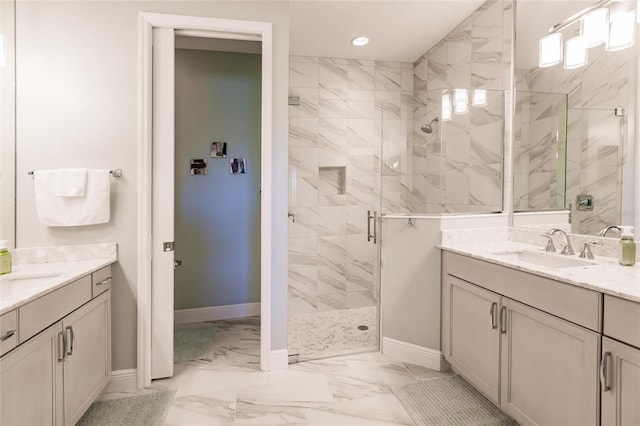 full bath with a stall shower, marble finish floor, two vanities, and a sink