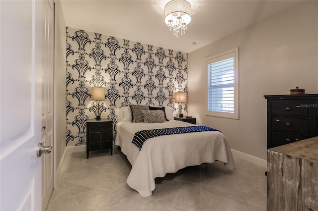 bedroom with a notable chandelier, an accent wall, tile patterned flooring, and baseboards