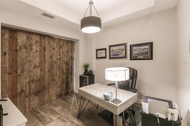 office space with visible vents, baseboards, and wood finished floors