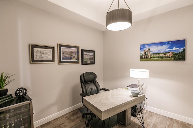 home office with baseboards and wood finished floors