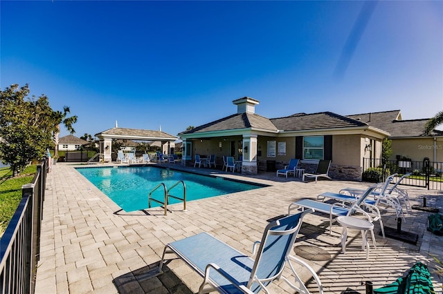 pool with a patio area and fence