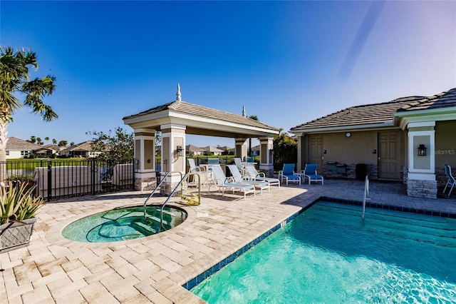 pool featuring a community hot tub, a patio area, fence, and a gazebo