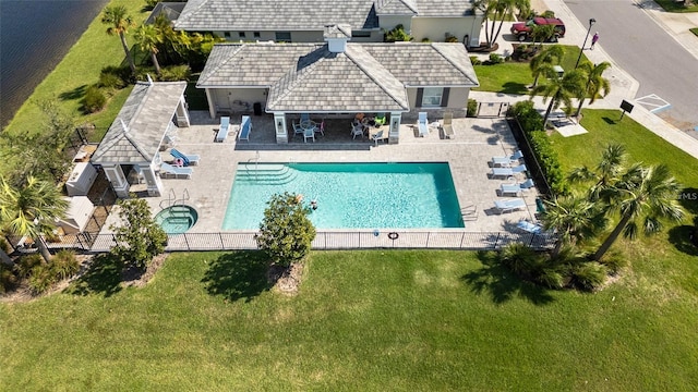 pool with a patio area, fence, and a water view