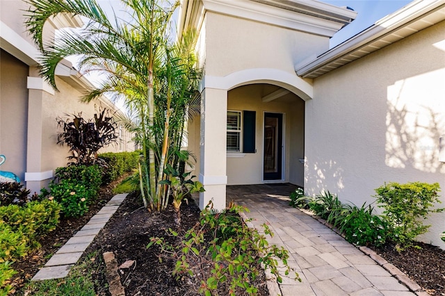 view of exterior entry with stucco siding