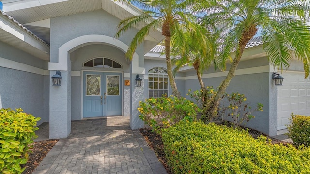 view of exterior entry with stucco siding and french doors