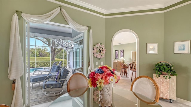 dining area with a sunroom and ornamental molding