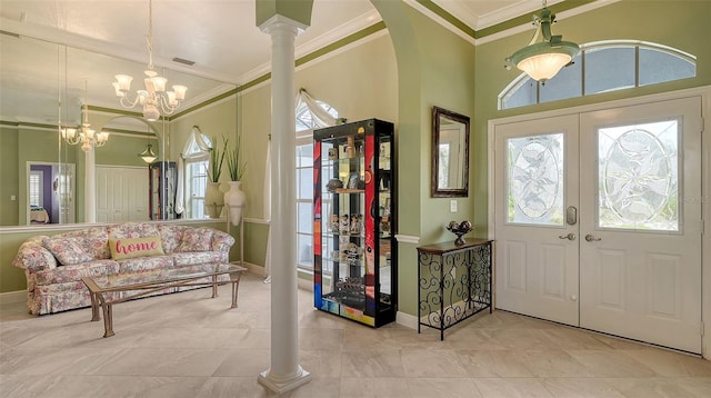 entrance foyer with visible vents, crown molding, baseboards, a chandelier, and arched walkways