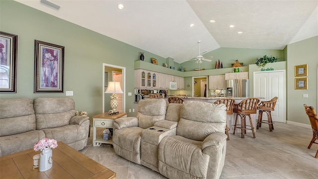 living area featuring lofted ceiling, light tile patterned flooring, a ceiling fan, and visible vents