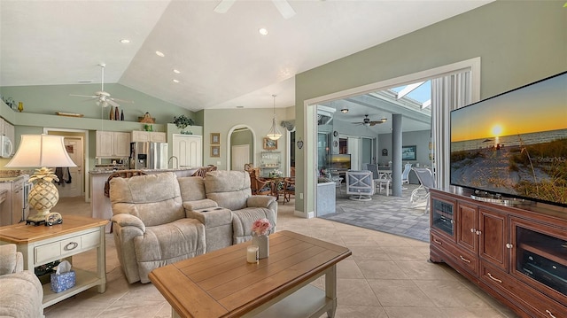 living area with lofted ceiling, light tile patterned floors, recessed lighting, arched walkways, and a ceiling fan