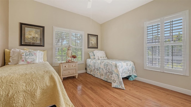 bedroom with baseboards, light wood-type flooring, and lofted ceiling