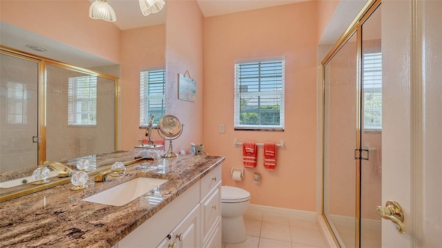 bathroom with tile patterned flooring, baseboards, toilet, a stall shower, and vanity